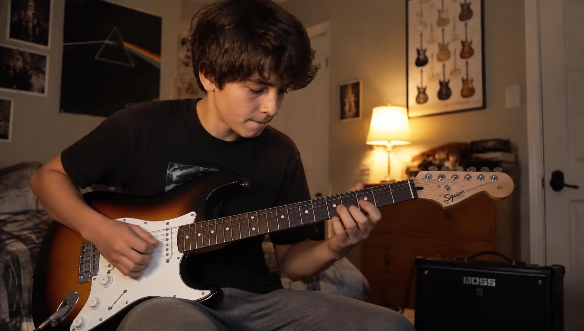 Hand van een gitarist die een snaar buigt tijdens een solo op podium